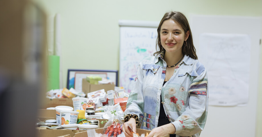 Karawanhaus Sachspenden  Eine junge Frau sortiert Sachspenden in Kisten